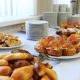 Catering banquet table with baked food snacks, sandwiches, cakes and plates, self serve, open buffet dinner, selective focus, horizontal view